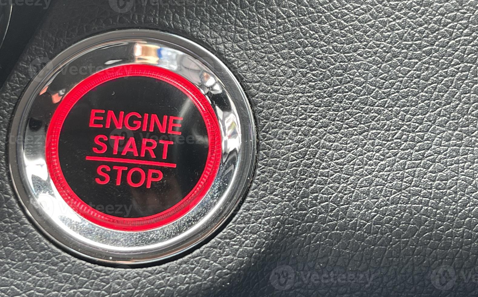 car engine start stop button on dark leather background. copy space photo