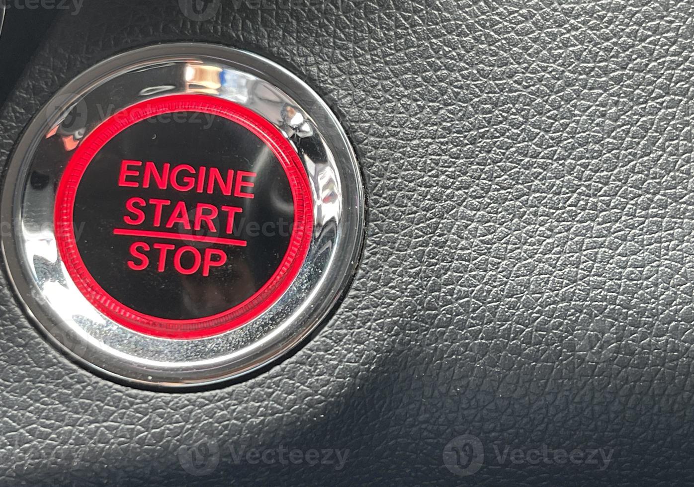 car engine start stop button on dark leather background. copy space photo