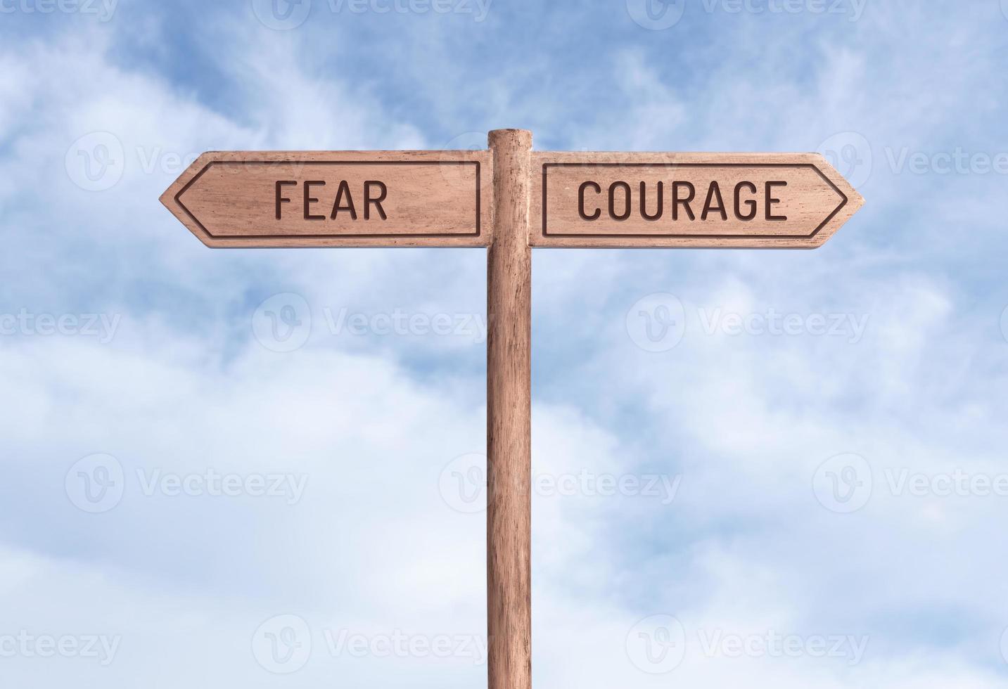 Fear or Courage concept. Words in opposite directions on signpost with sky background photo