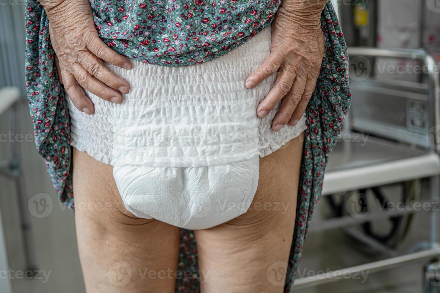 Paciente asiático mayor o mayor de la mujer de la señora mayor que lleva el pañal de la incontinencia en la sala del hospital de enfermería, concepto médico fuerte sano. foto