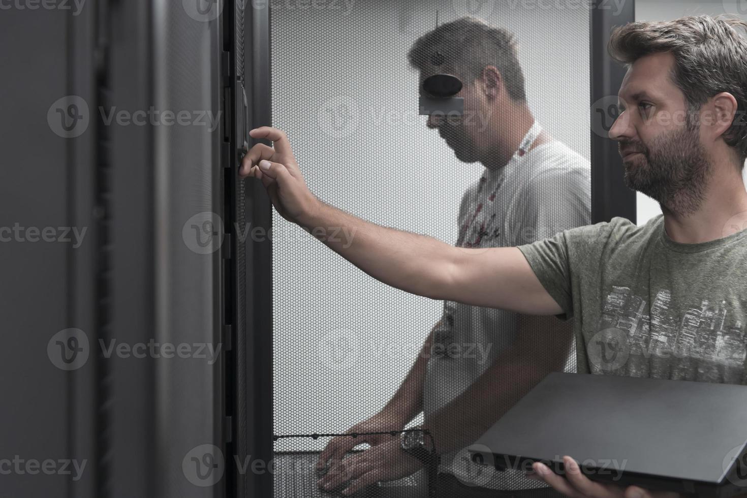 Technicians team updating hardware inspecting system performance in super computer server room or cryptocurrency mining farm. photo