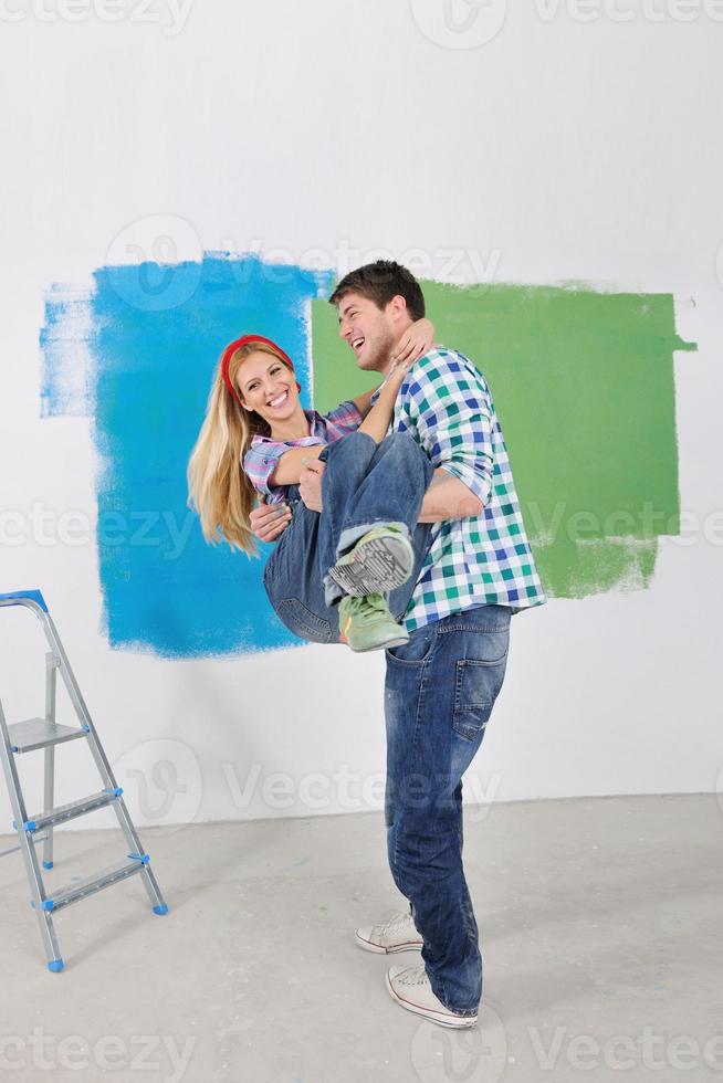 happy couple paint wall at new home photo