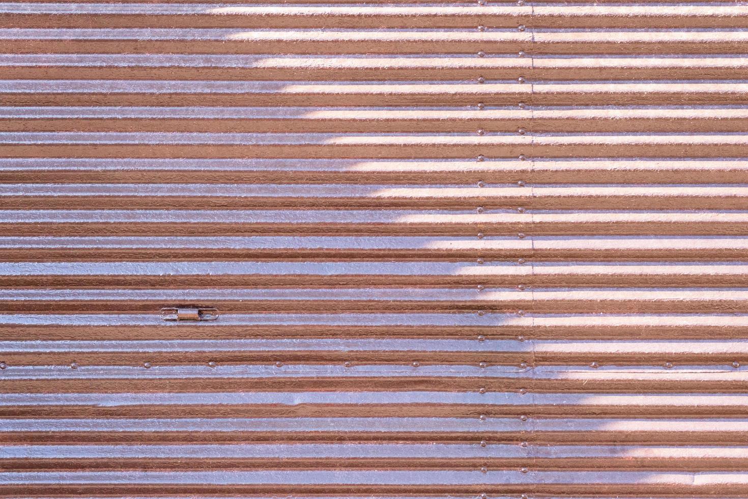 Rusty metal striped wall of the garage, grunge texture and pattern, dirty textured steel painted door with peeling paint, background, abstract horizontal lines. photo