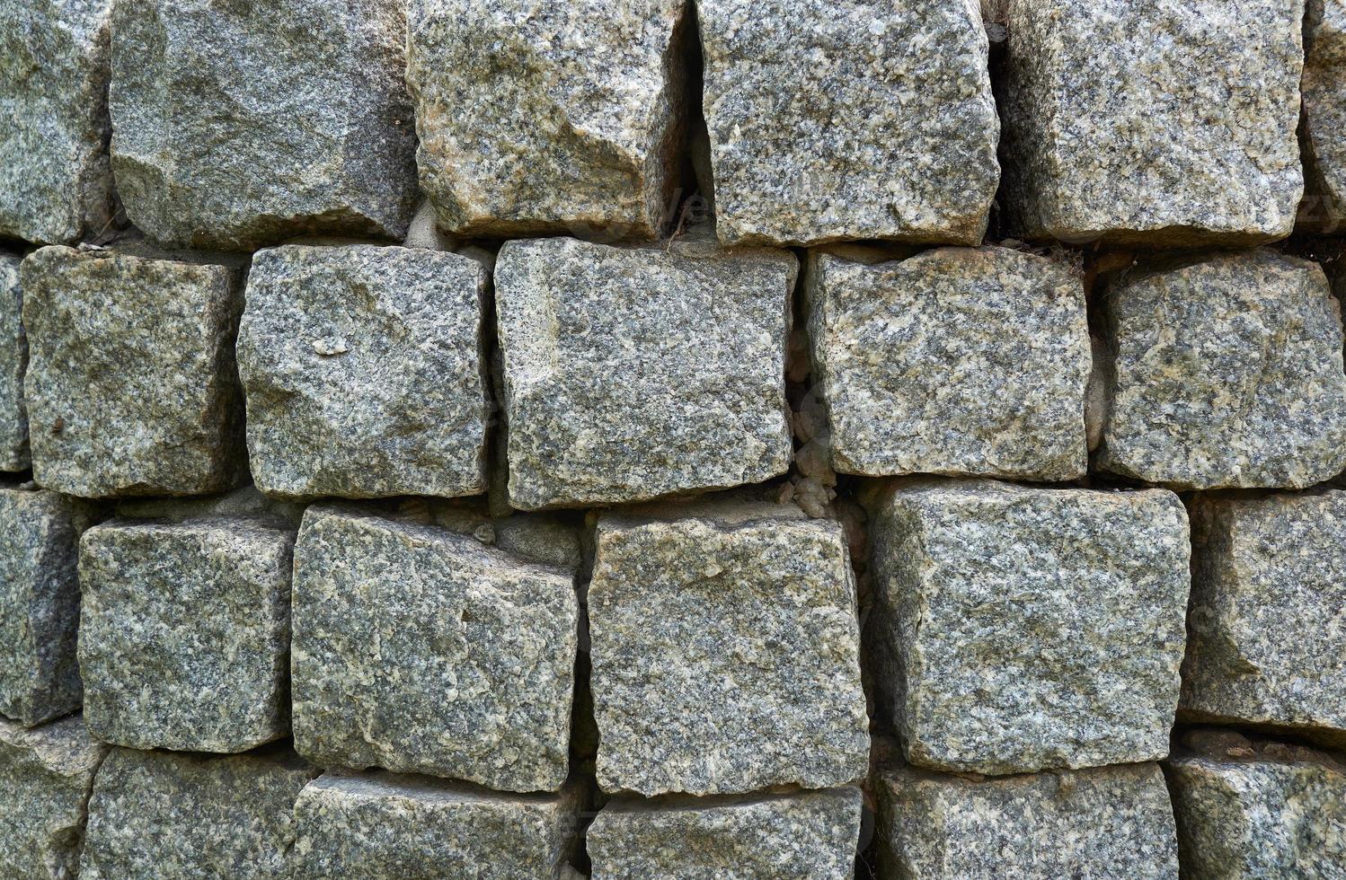Abstract background of lined wall of granite stones of square shape. photo