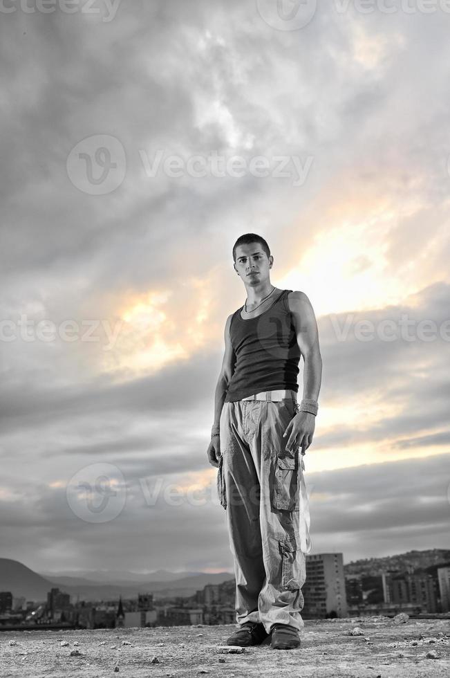 young man dancing and jumping  on top of the building photo