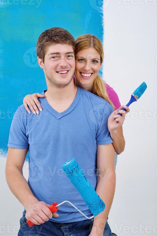 happy couple paint wall at new home photo