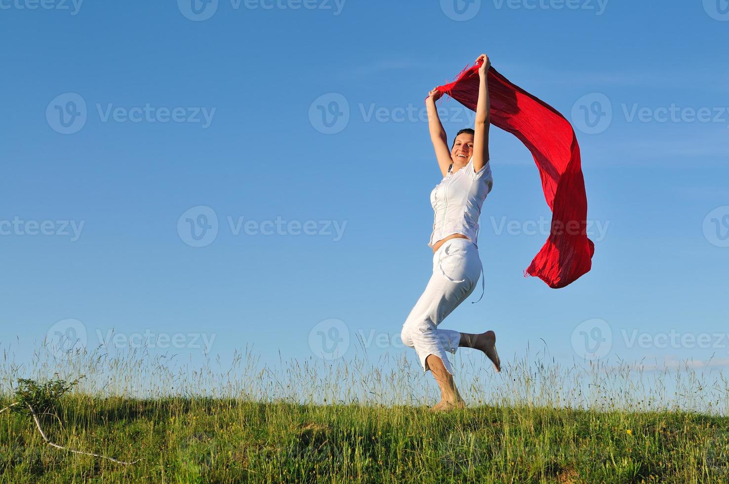 beautiful woman with red scarf on meadow photo