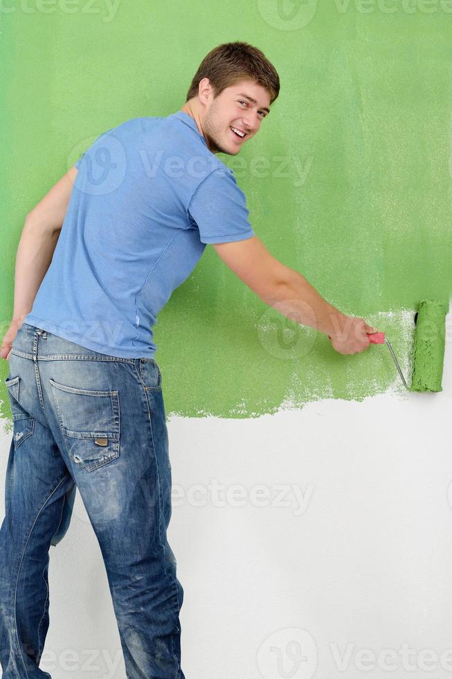 handsome young man paint white wall in color photo