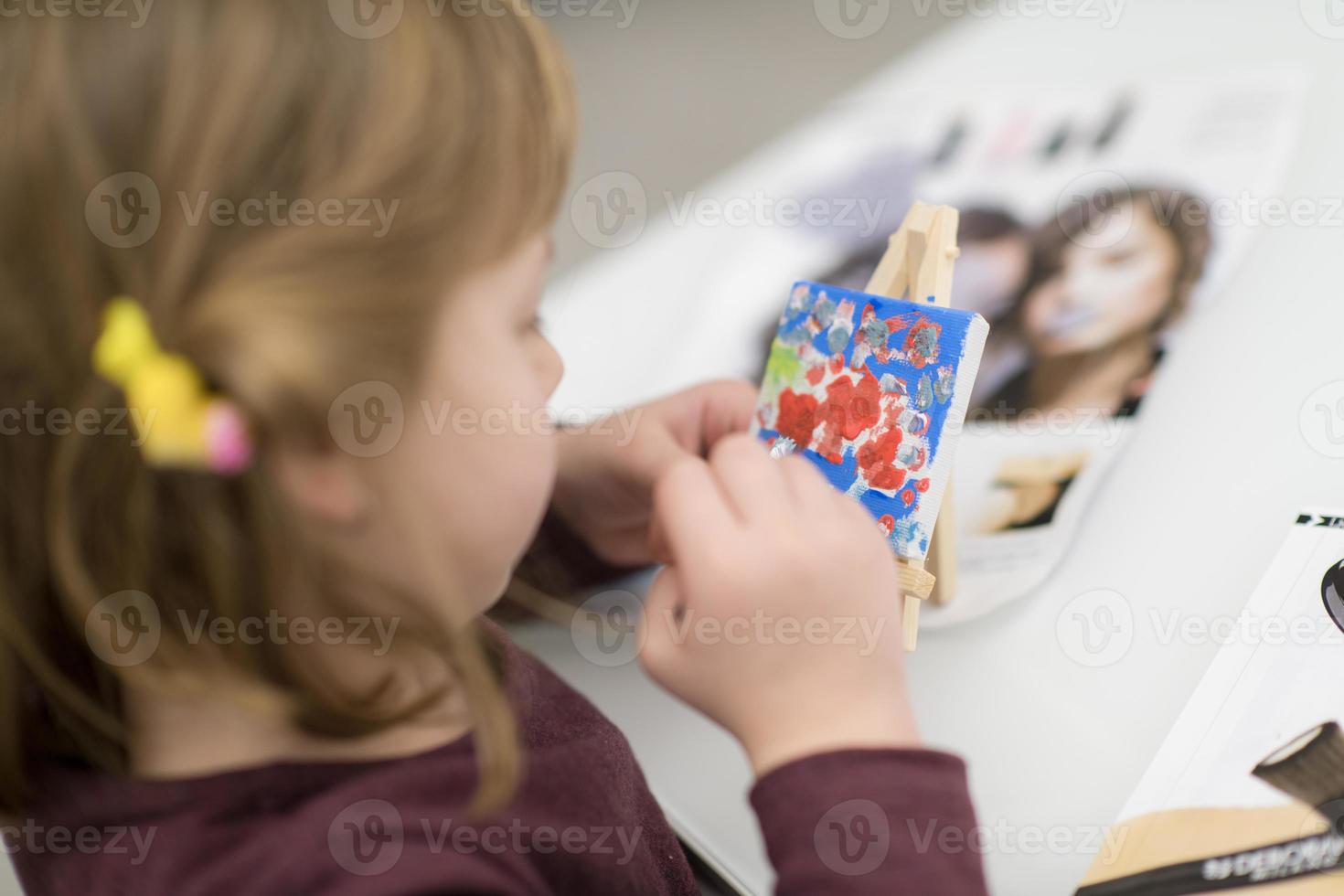 little girl painting on canvas photo