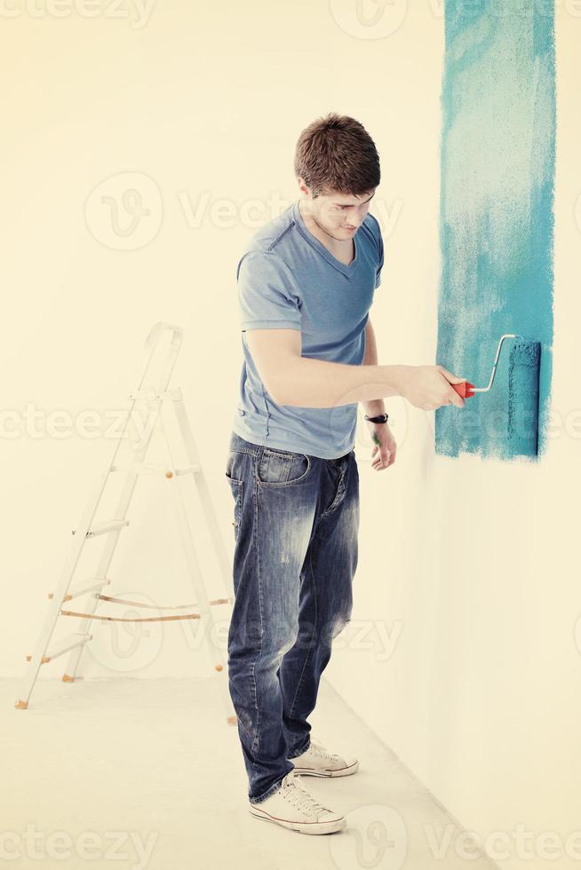 handsome young man paint white wall in color photo