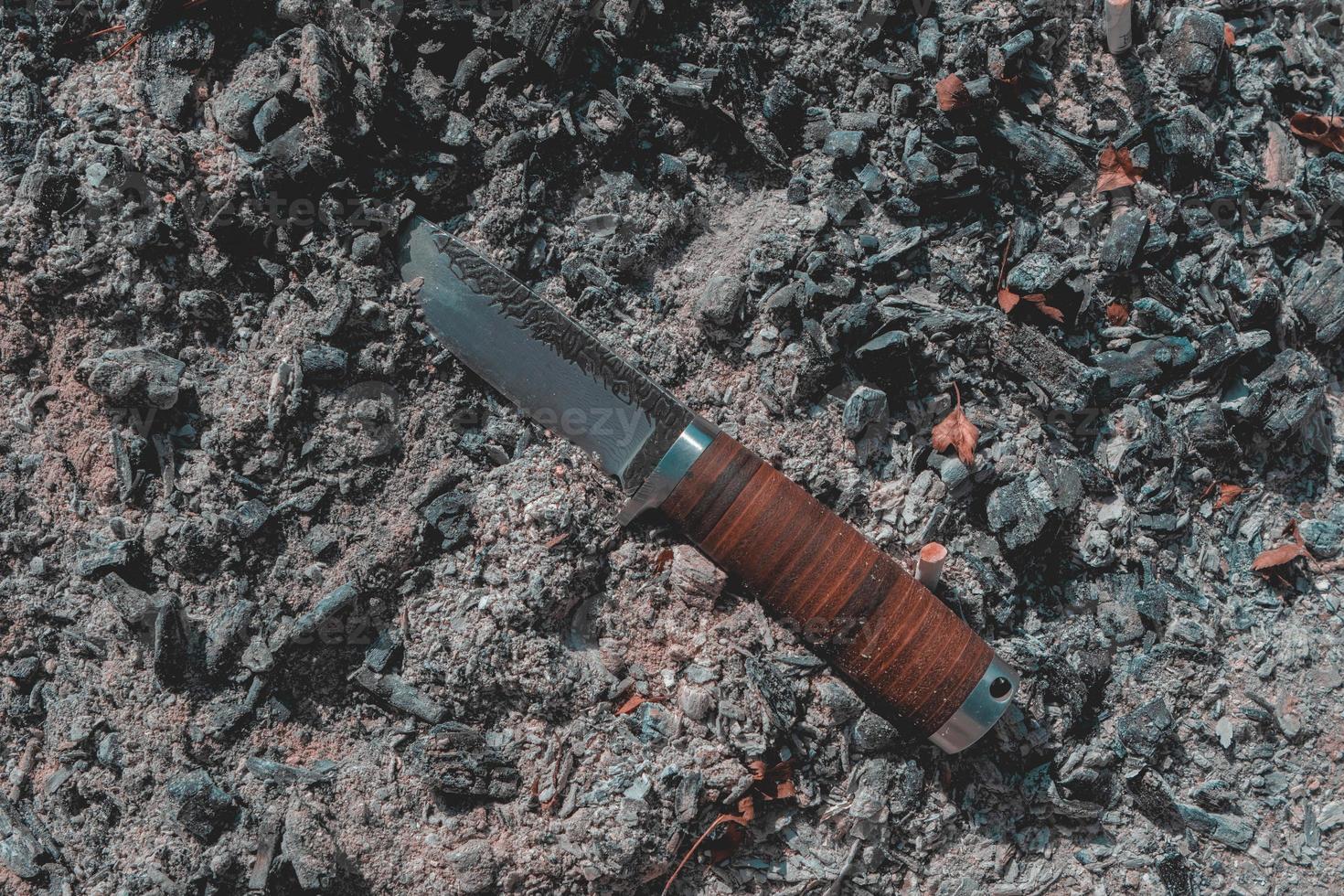 Hunting knife on a Coal surface photo