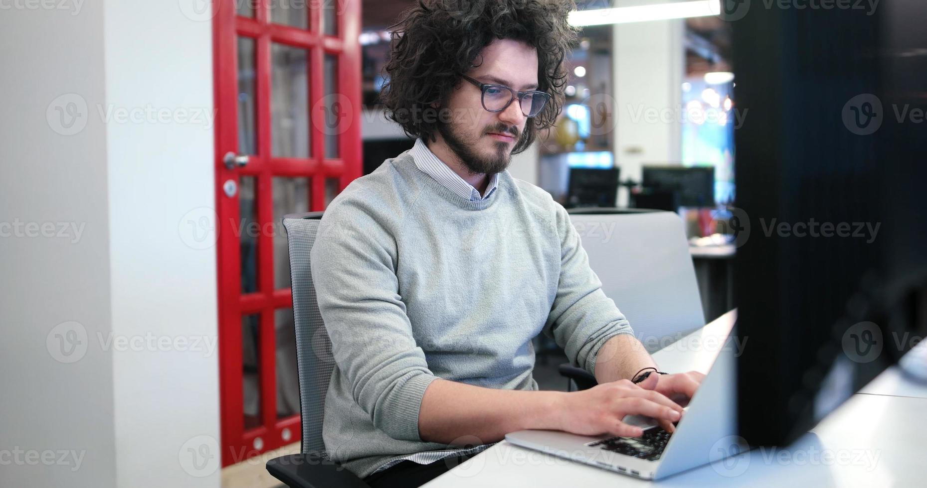 hombre de negocios que trabaja usando una computadora portátil en la oficina de inicio foto