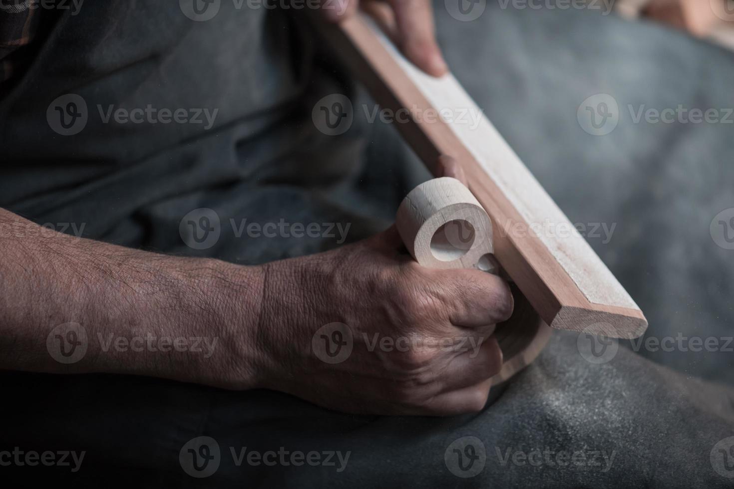 Hands carving cup from wood, working with chisel close up. Wooden workshop. Process of making wooden kitchenware photo