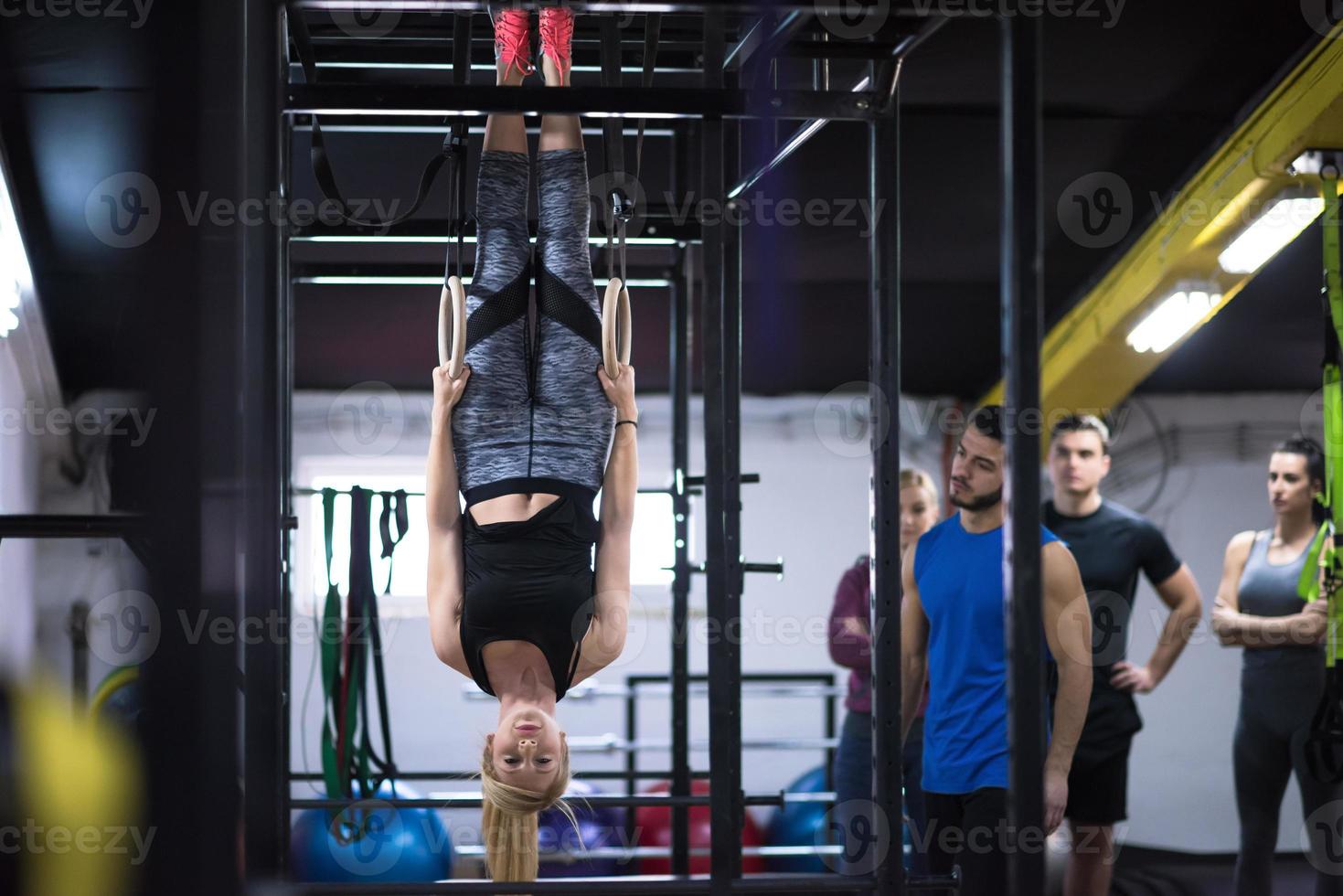 mujer trabajando con entrenador personal en anillos de gimnasia foto