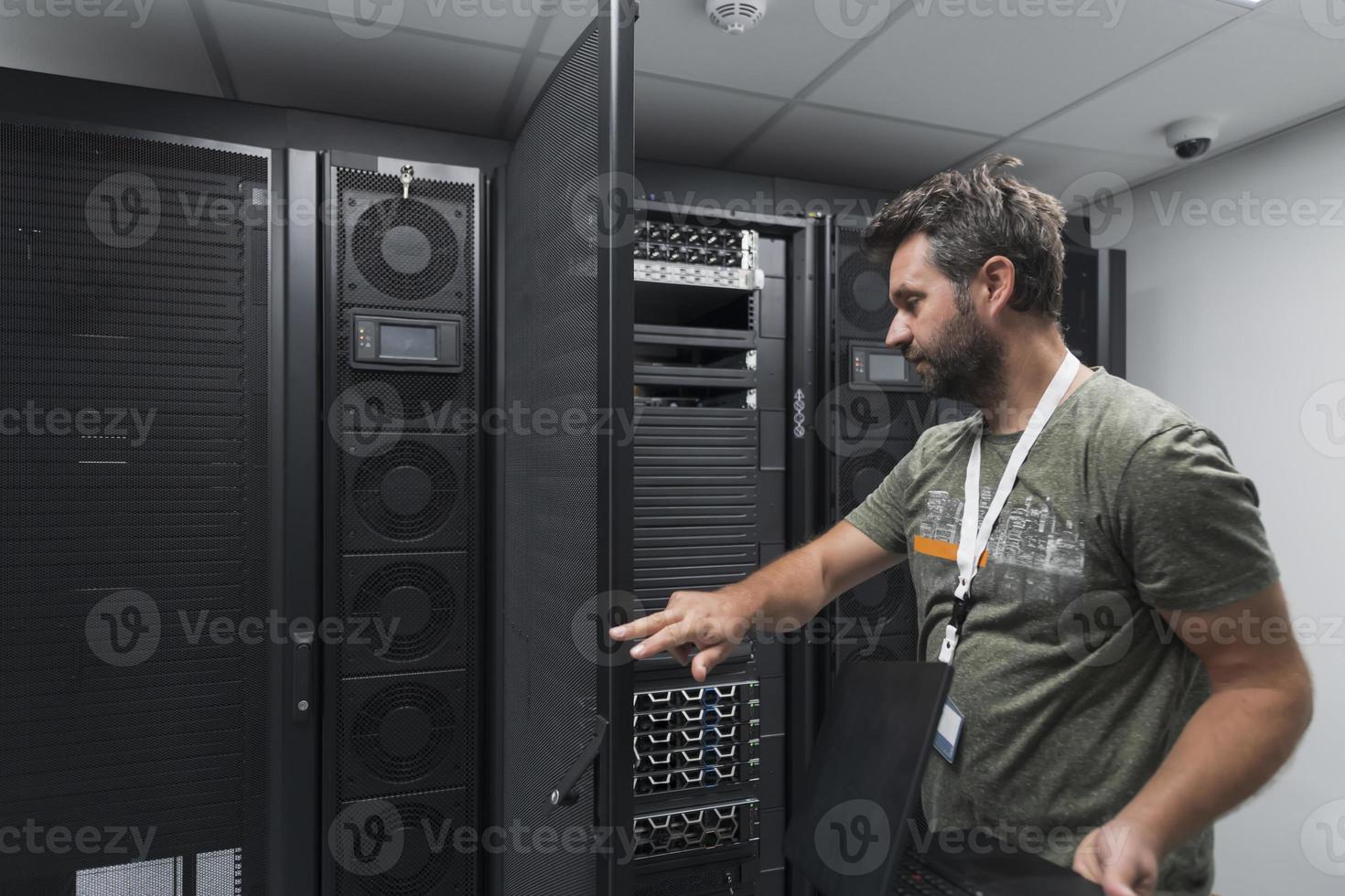 Data Center Engineer Usaing Keyboard on a Supercomputer Server Room Specialist Facility with Male System Administrator photo