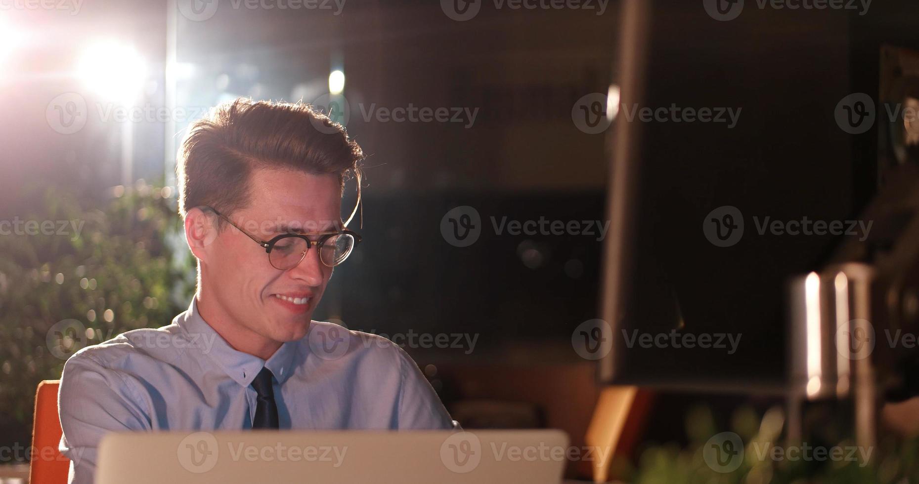 man working on computer in dark office photo