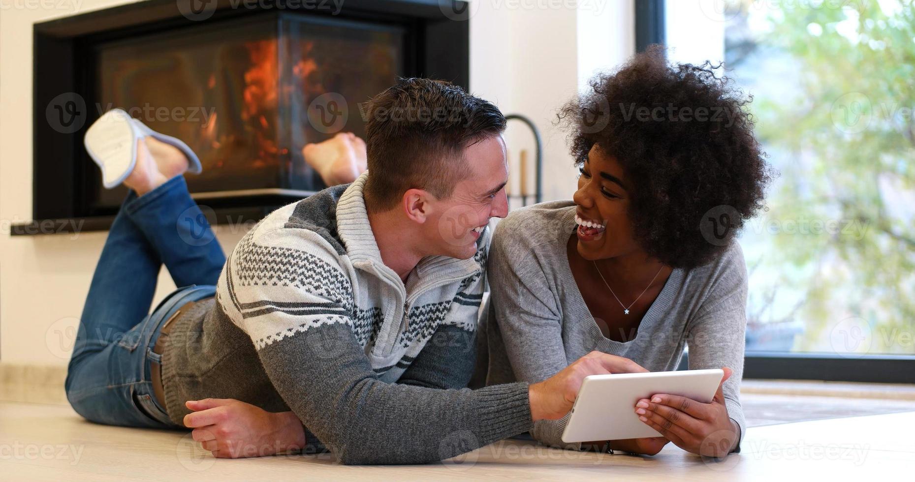 multiethnic couple using tablet computer on the floor photo