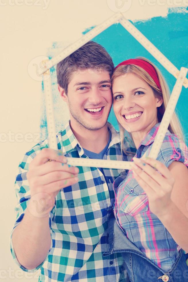 pareja feliz pintando una pared en su nuevo hogar foto