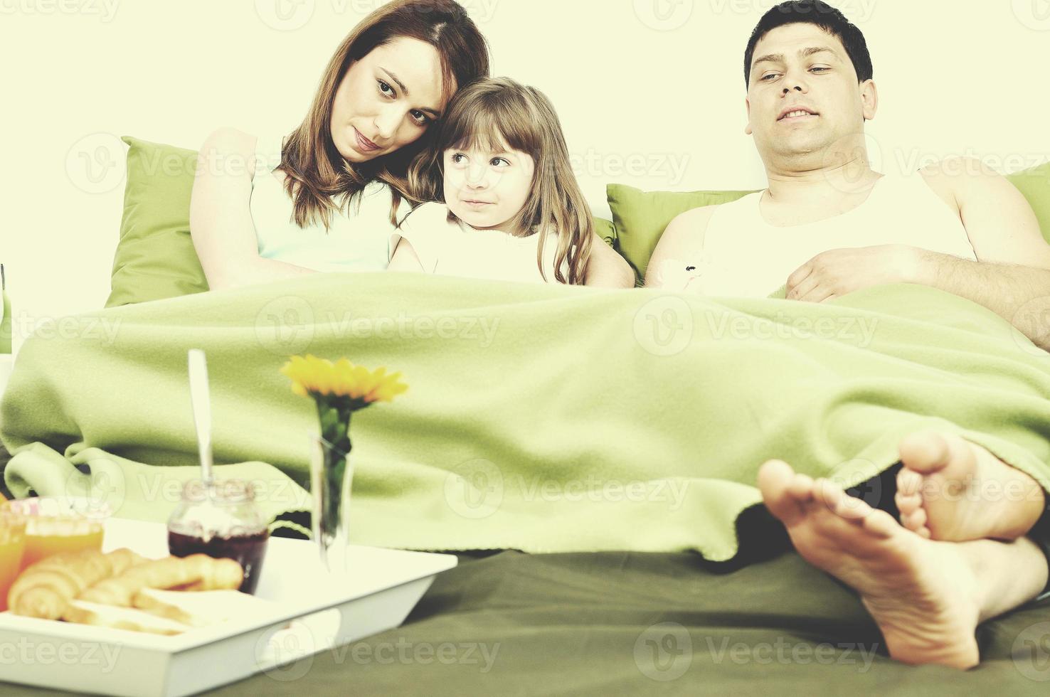 happy young family eat breakfast in bed photo