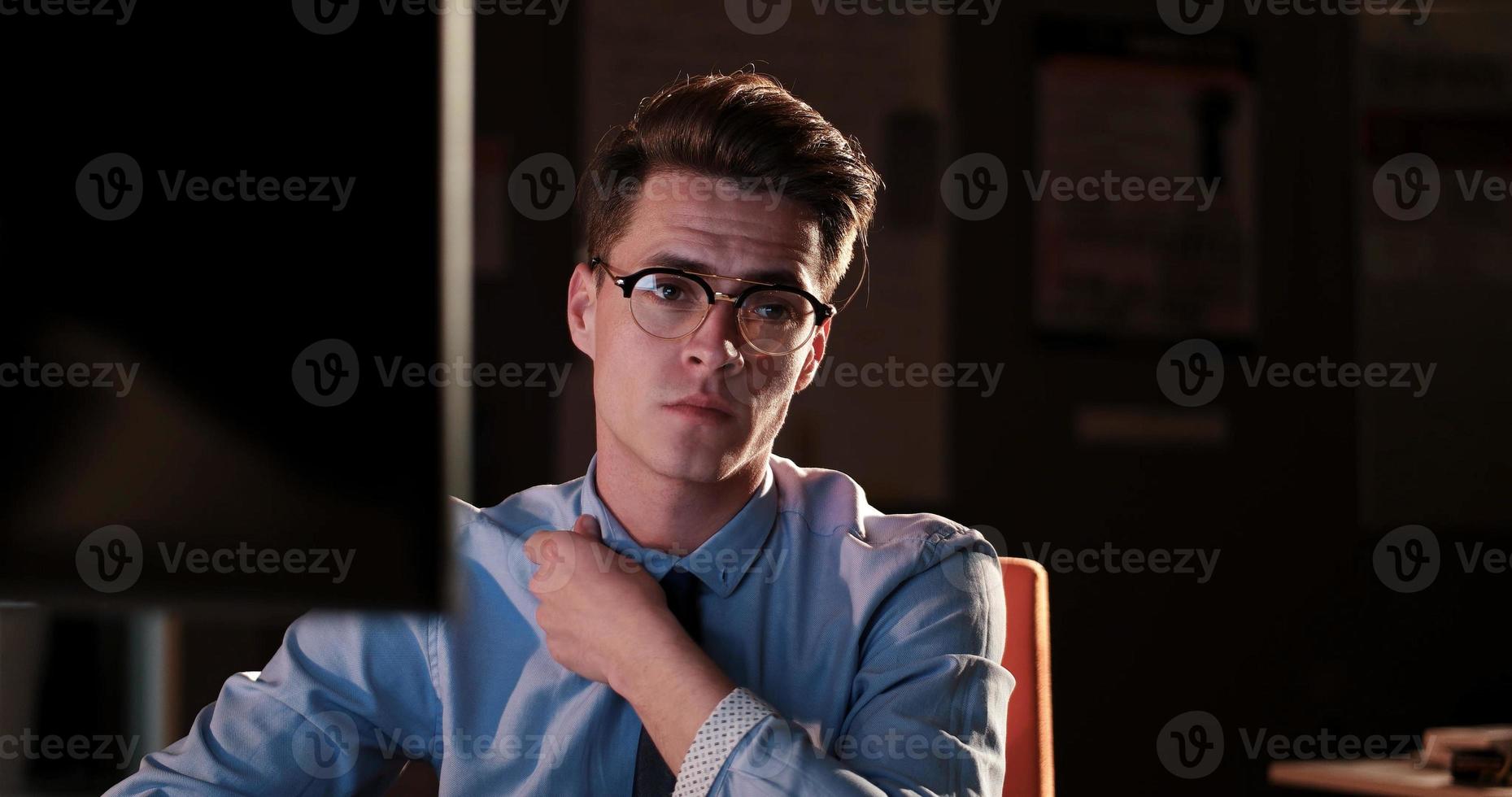 man working on computer in dark office photo