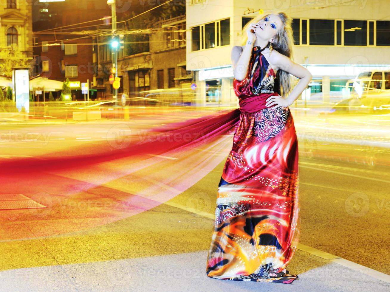 mujer elegante en la calle de la ciudad por la noche foto