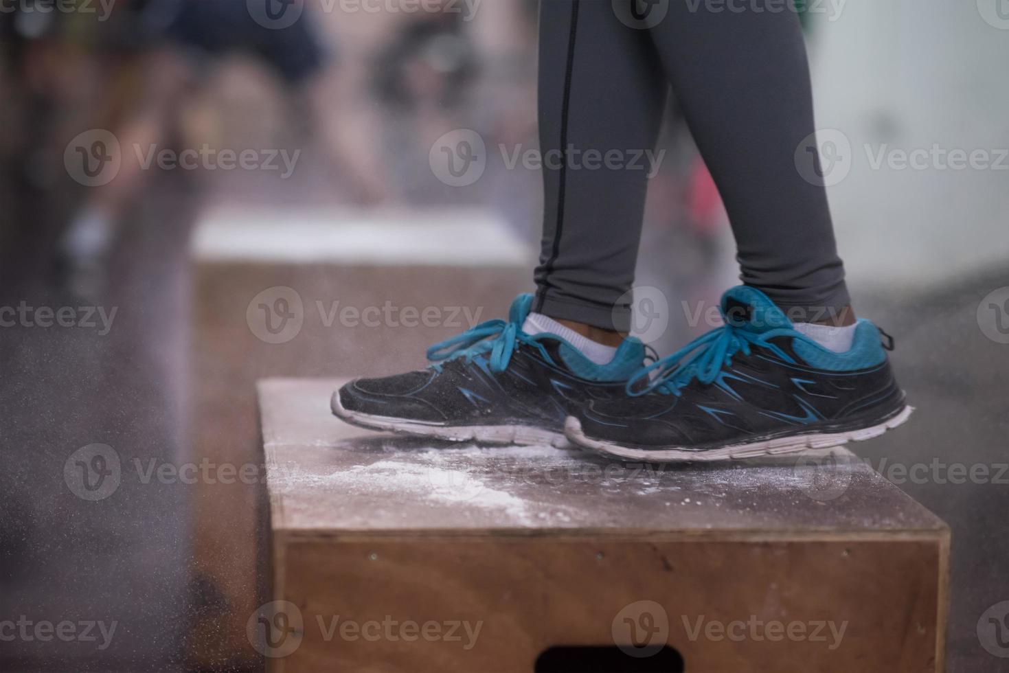 black woman is performing box jumps at gym photo