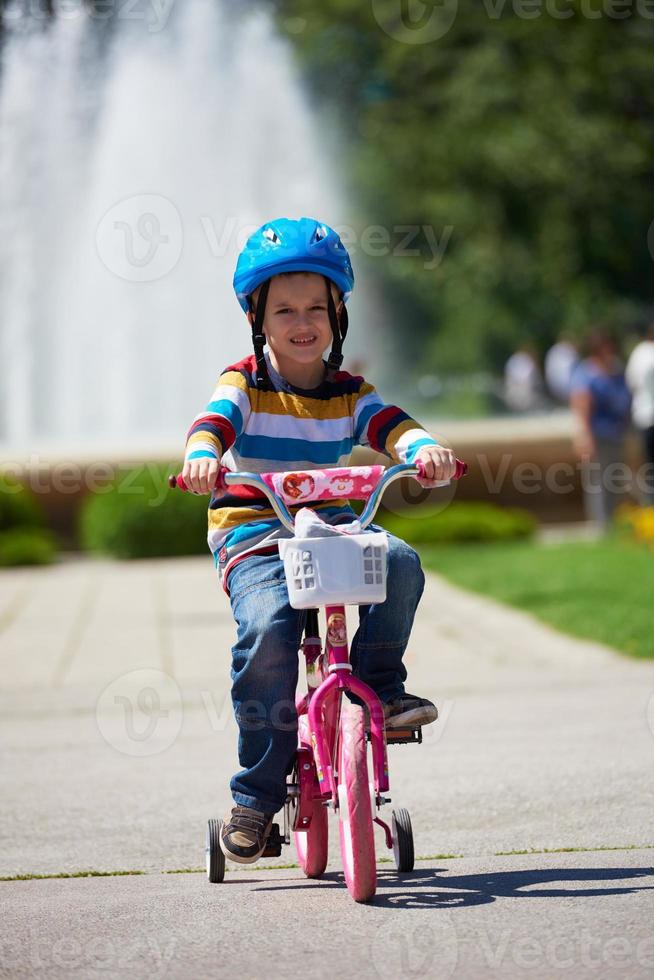 happy boy learning to ride his first bike photo