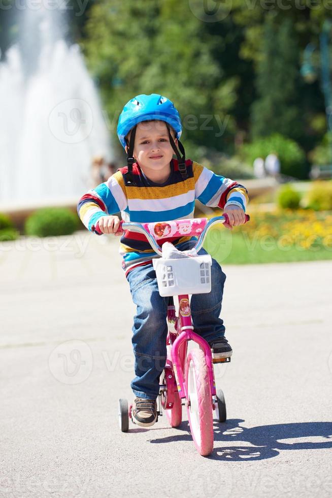 happy boy learning to ride his first bike photo