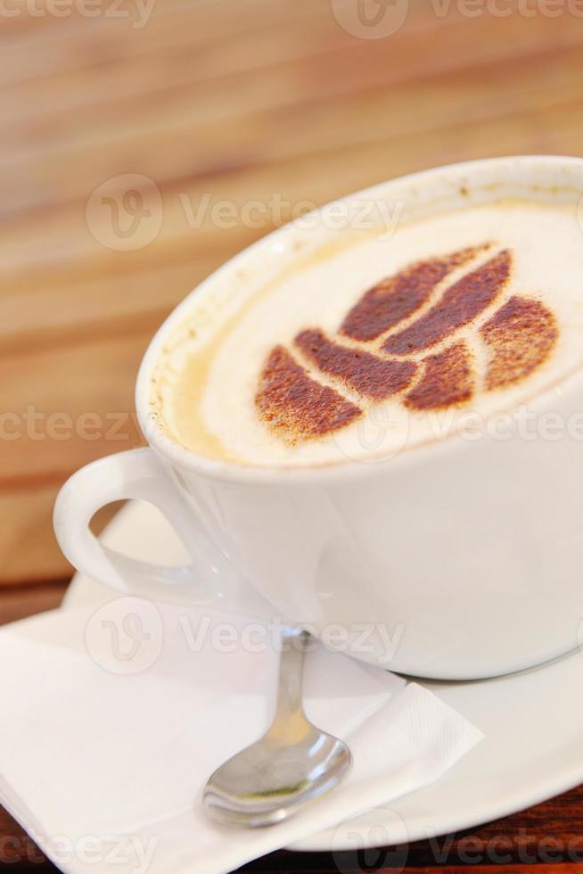 A cup of cappuccino, coffee and breakfast pastries on a wooden table with a  laptop computer for work and accessories. Generative AI Stock Photo