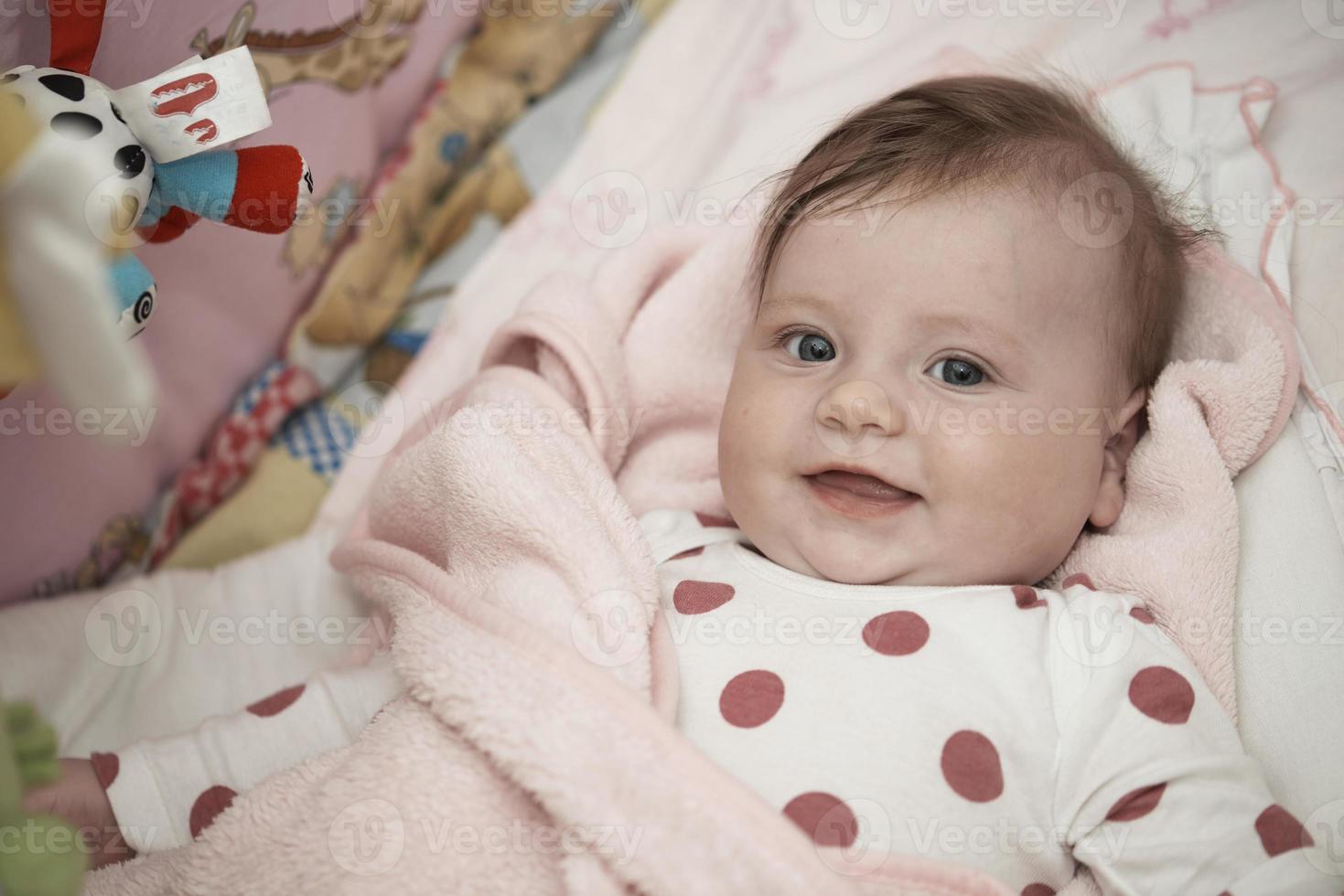 cute little baby playing with hands and smiling photo