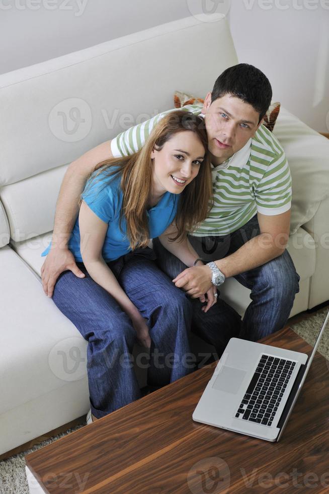young couple working on laptop at home photo