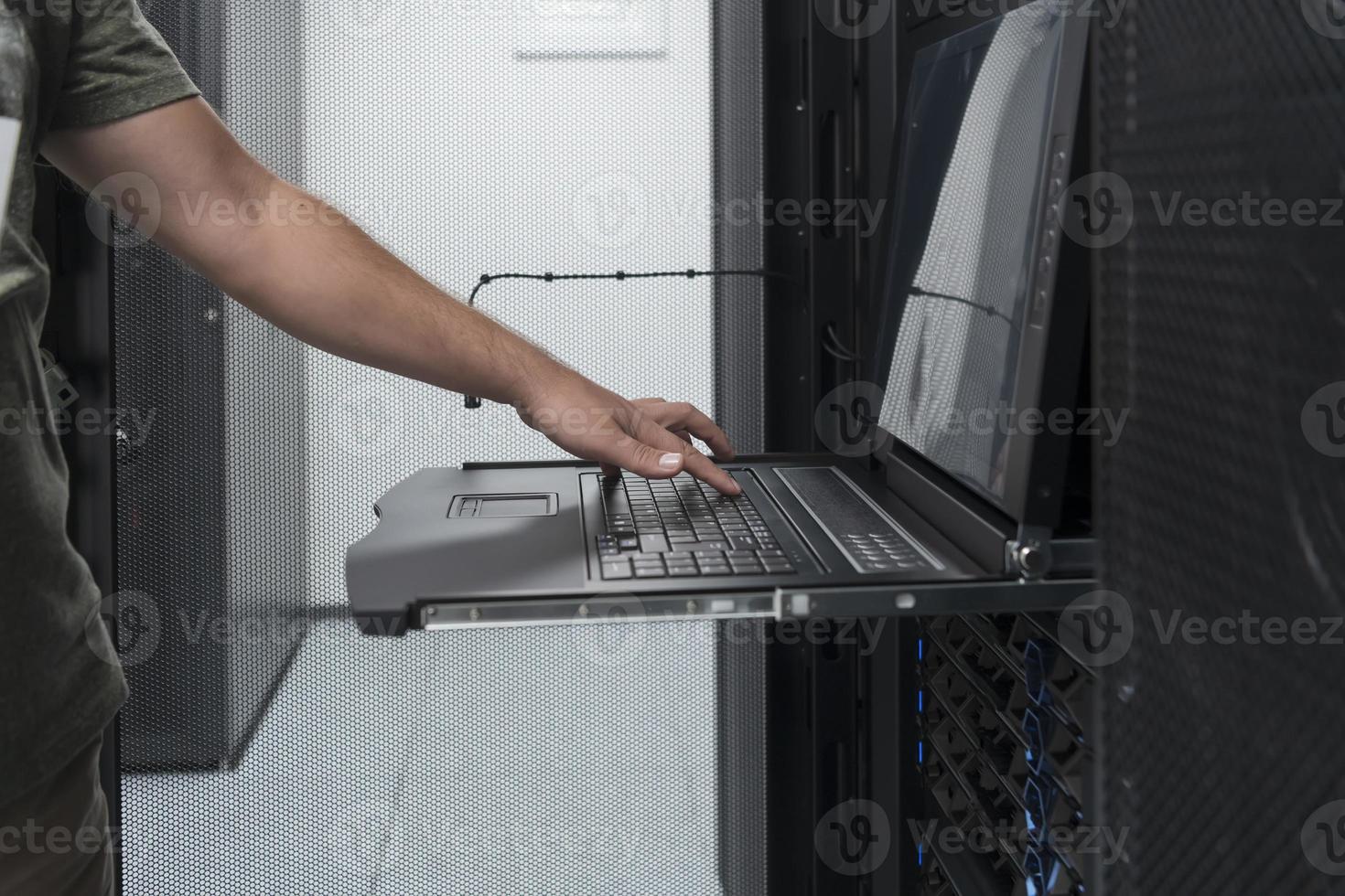 Close up on Data Center Engineer hands Using keyboard on a supercomputer Server Room Specialist Facility with Male System Administrator Working with Data Protection Network for Cyber Security. photo