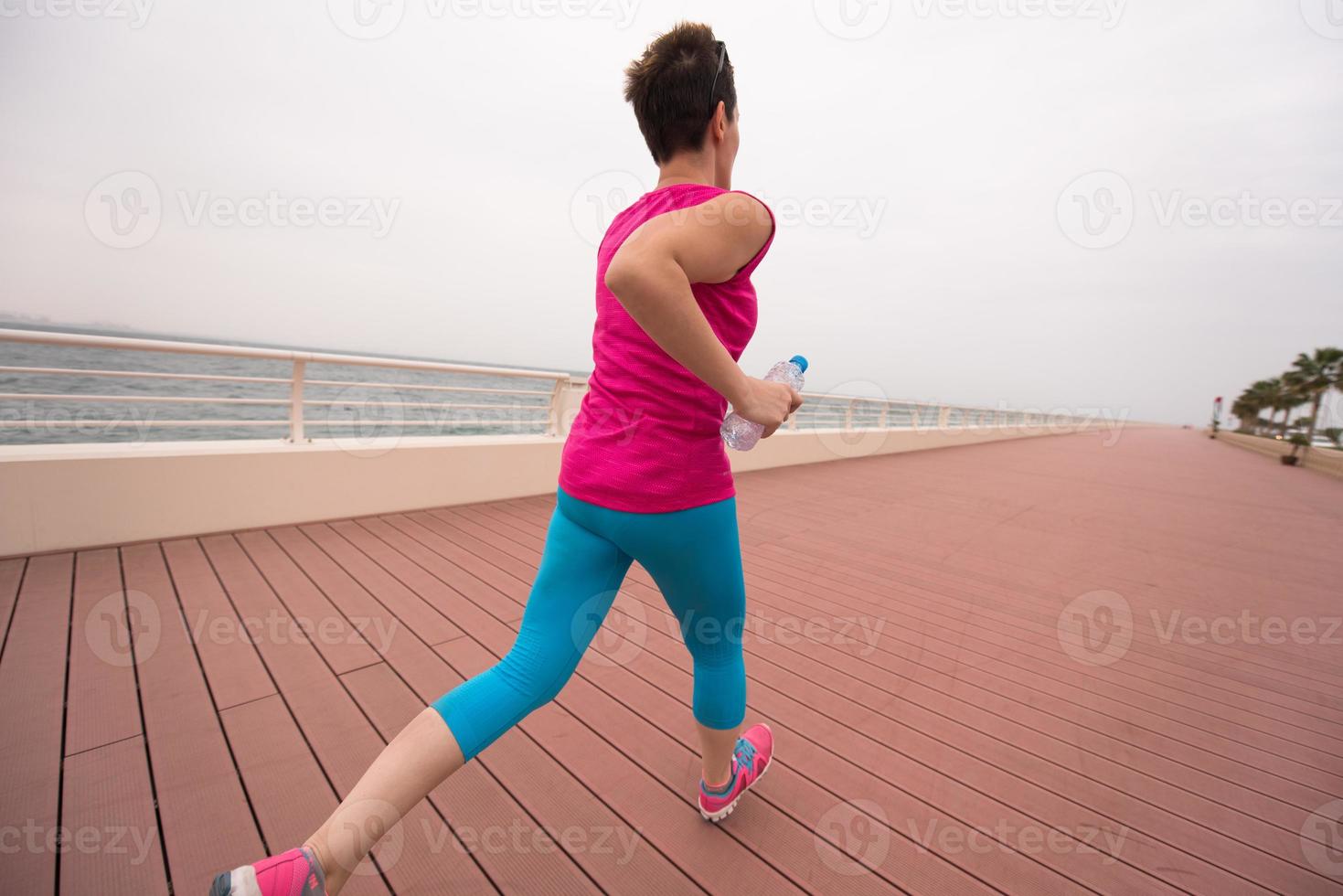 woman busy running on the promenade photo