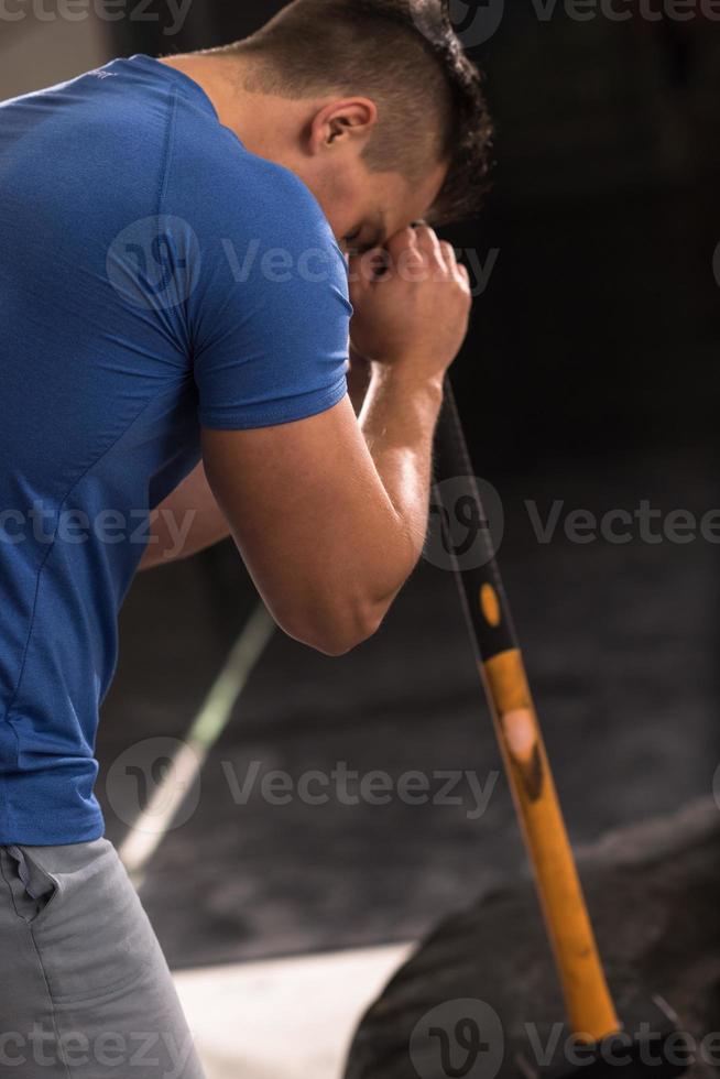 man workout with hammer and tractor tire photo