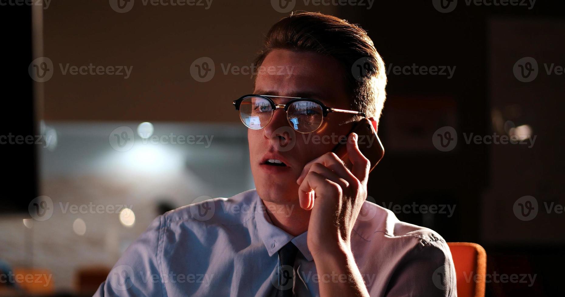 man using mobile phone in dark office photo