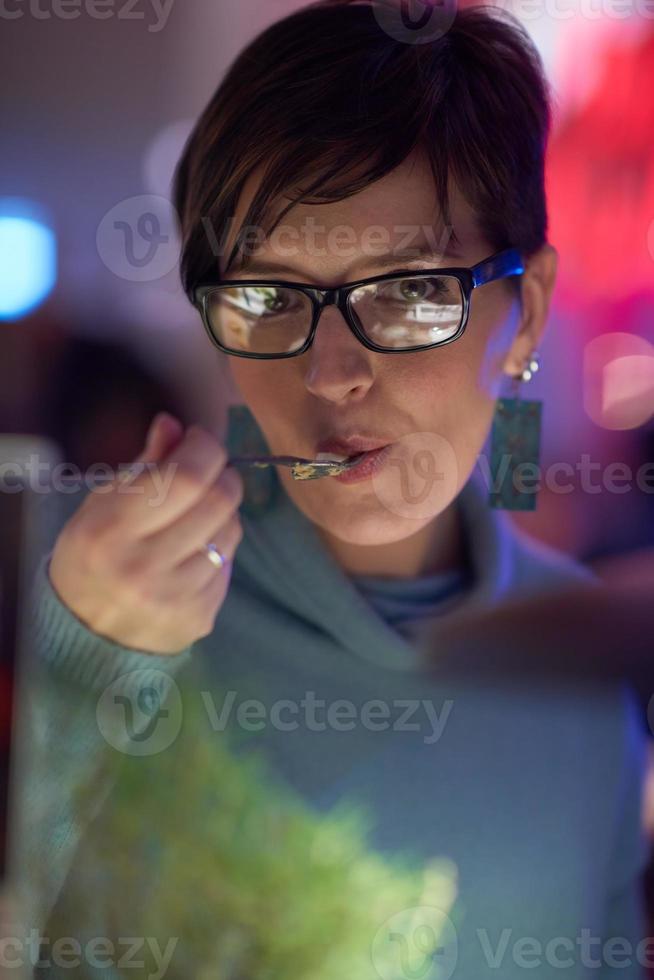 woman eating tasty dinner in modern restaurant photo