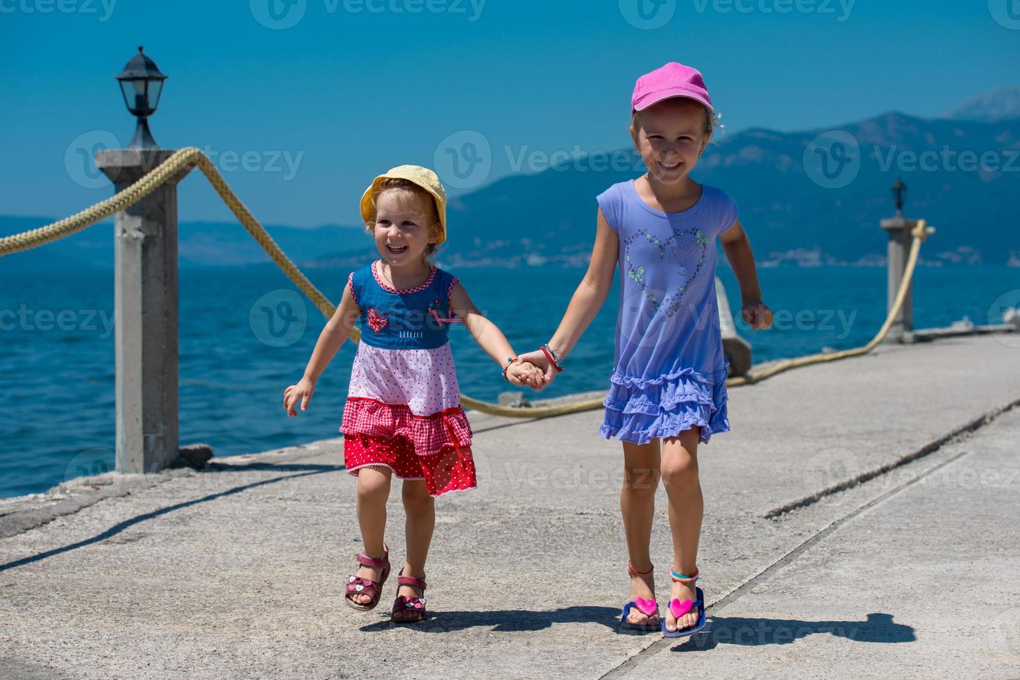 little sisters running on the beach coast photo