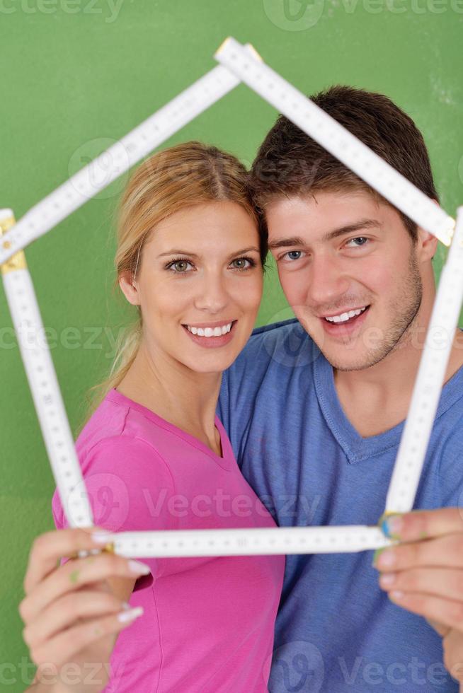 pareja feliz pintando una pared en su nuevo hogar foto