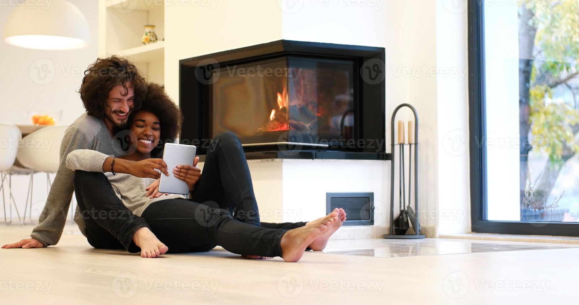 multiethnic couple using tablet computer on the floor photo