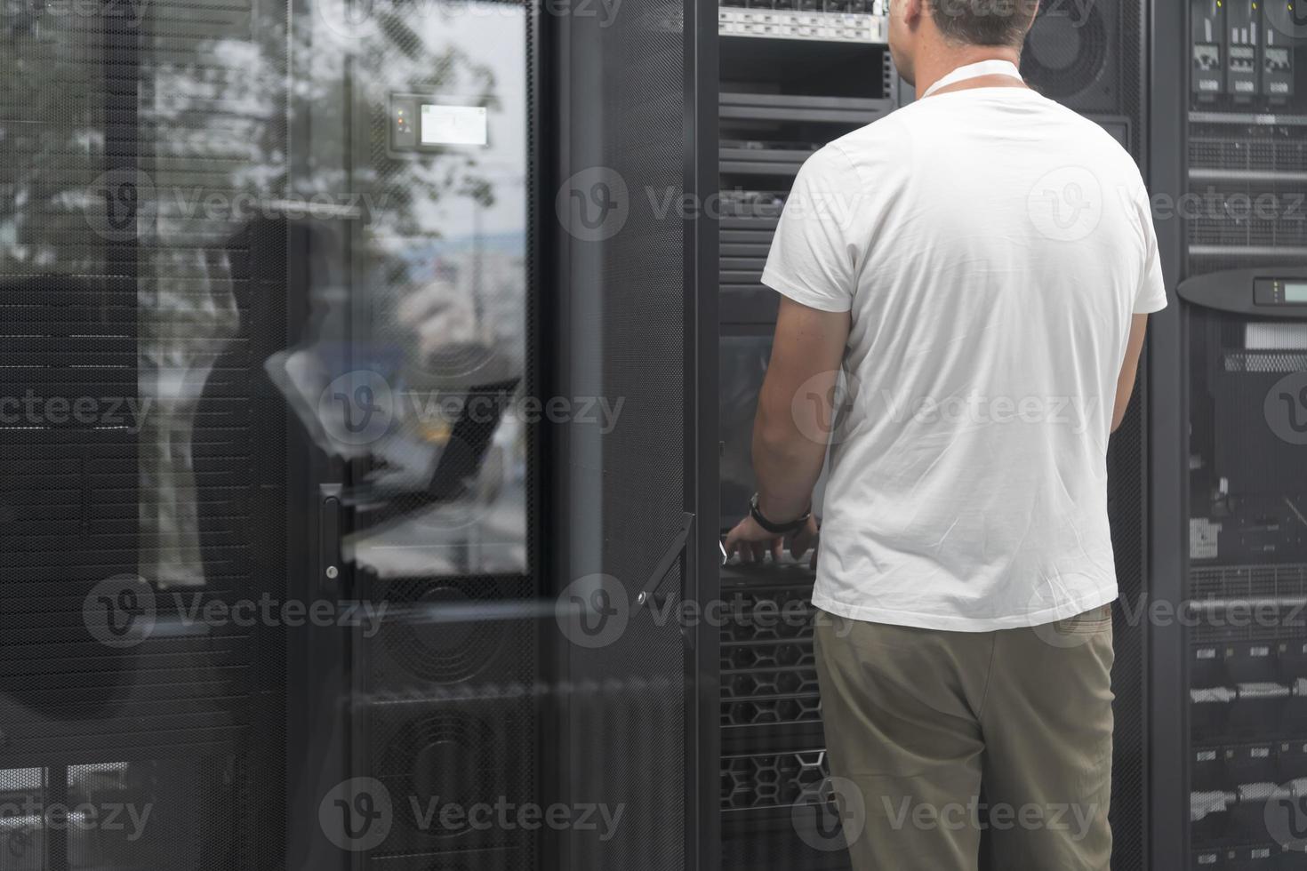 Technicians team updating hardware inspecting system performance in super computer server room or cryptocurrency mining farm. photo