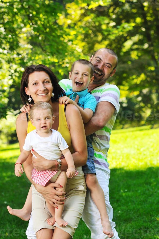 Feliz pareja joven con sus hijos divertirse en el parque foto