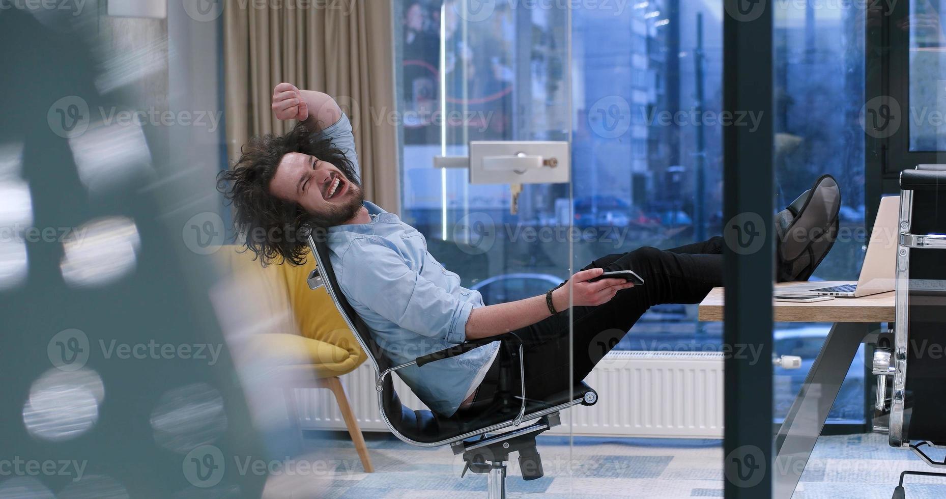 businessman sitting with legs on desk photo