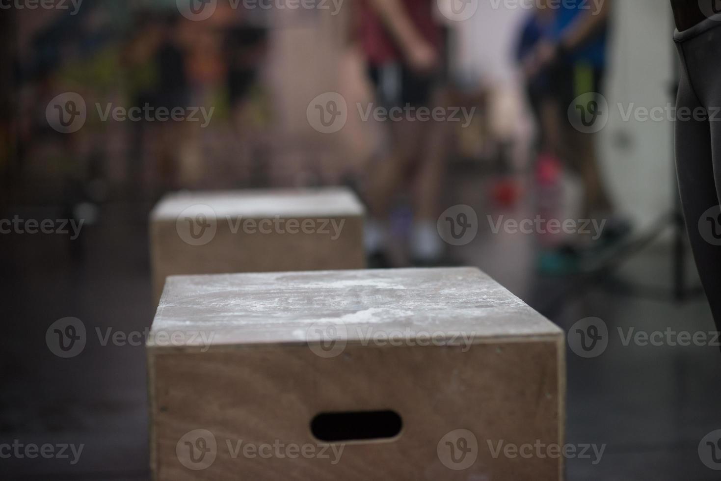 black woman is performing box jumps at gym photo