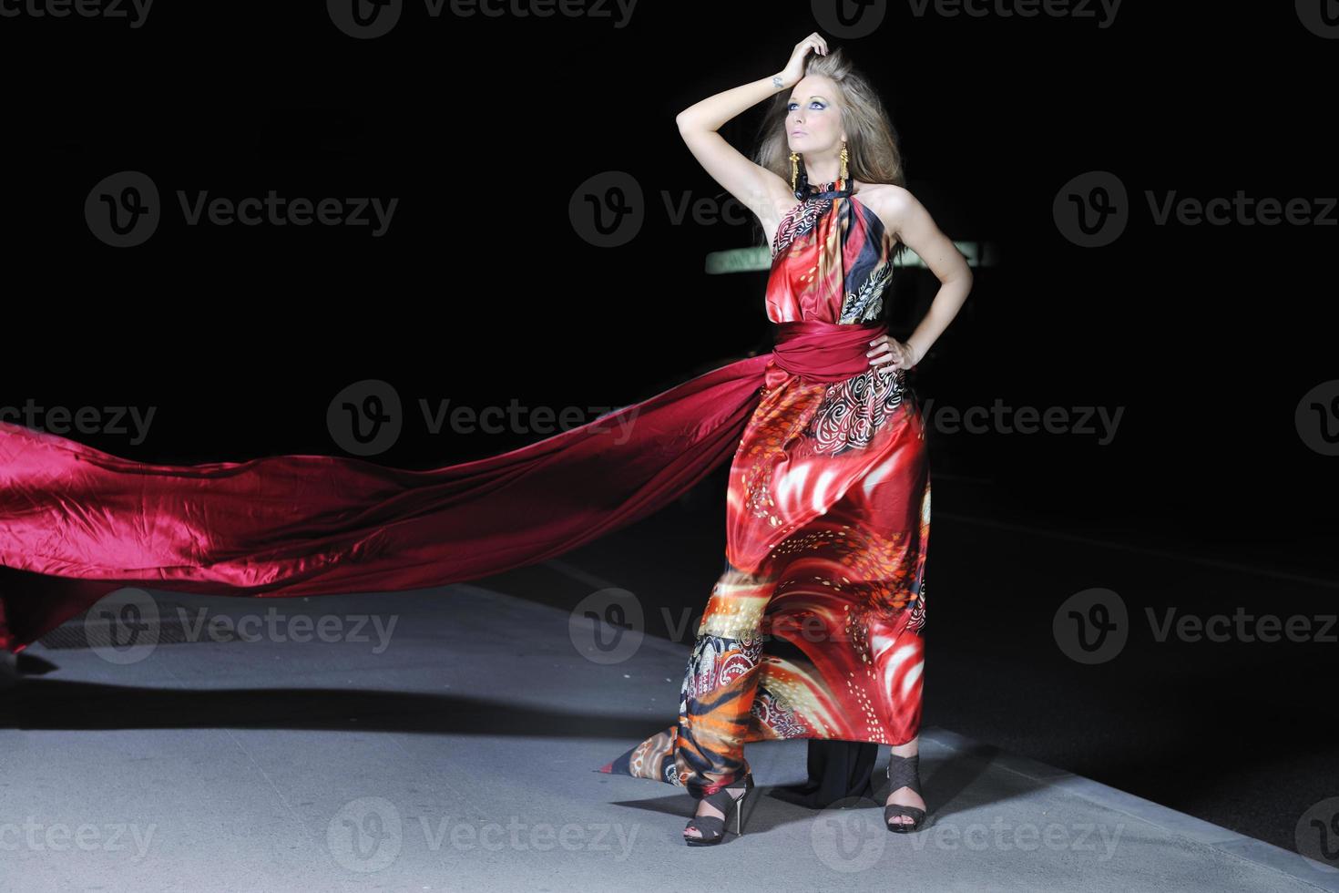 elegant woman on city street at night photo