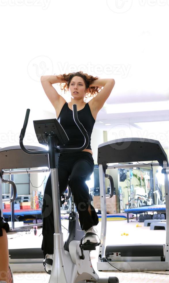 Women working out on spinning bikes at the gym photo