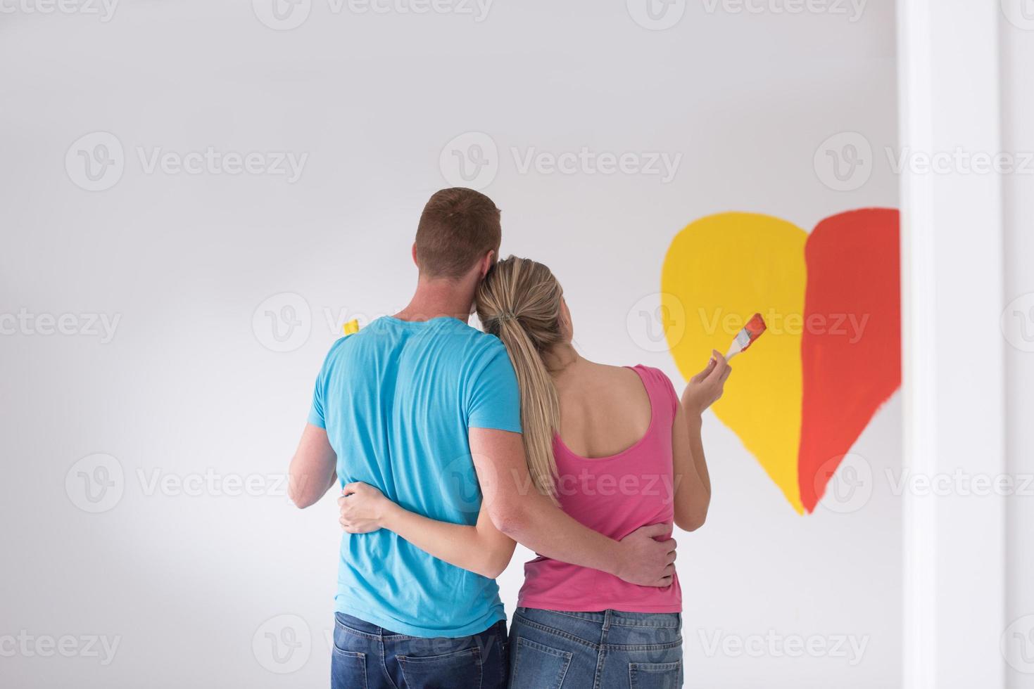 pareja está pintando un corazón en la pared foto