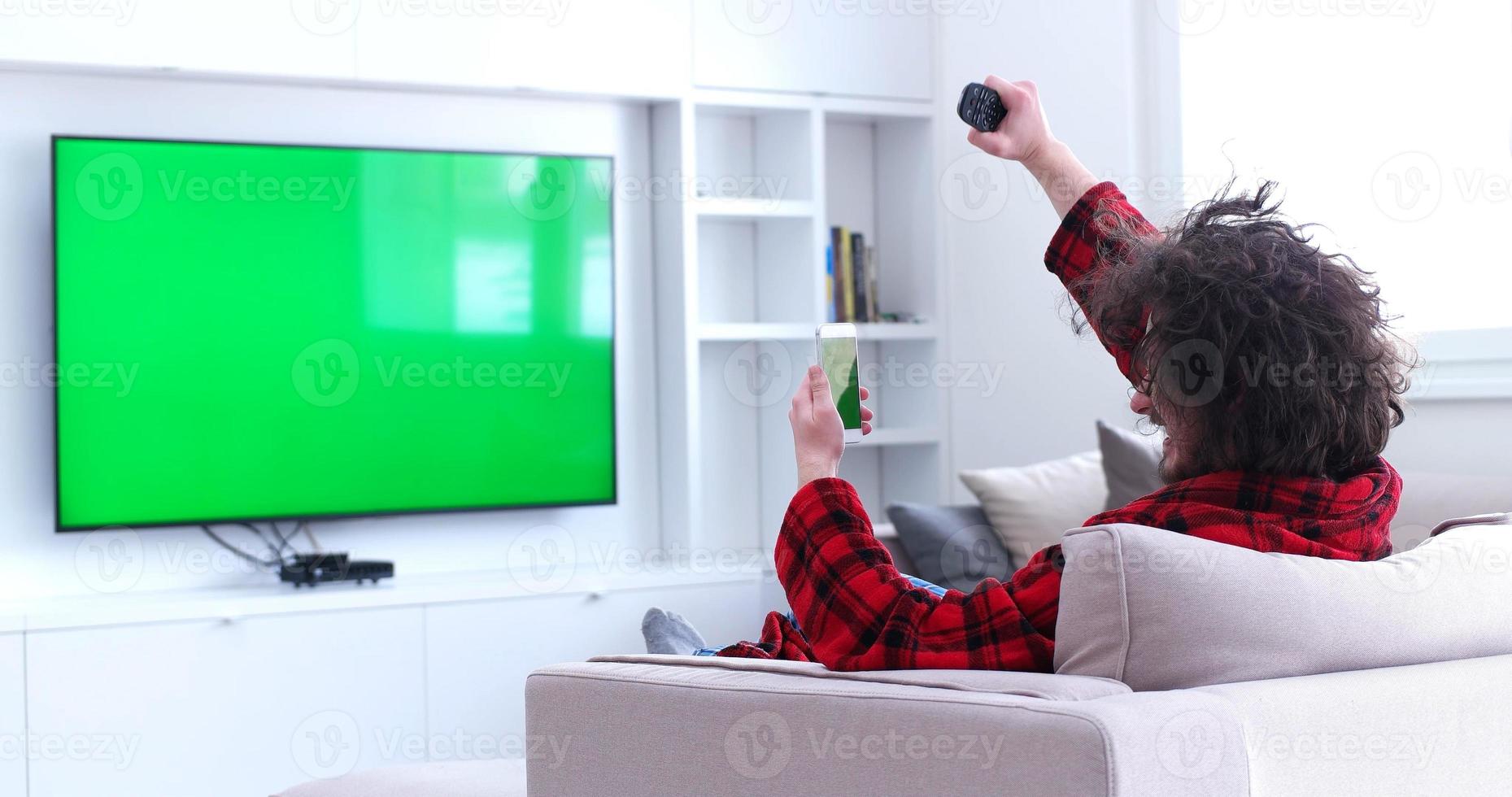 Young couple on the sofa watching television photo