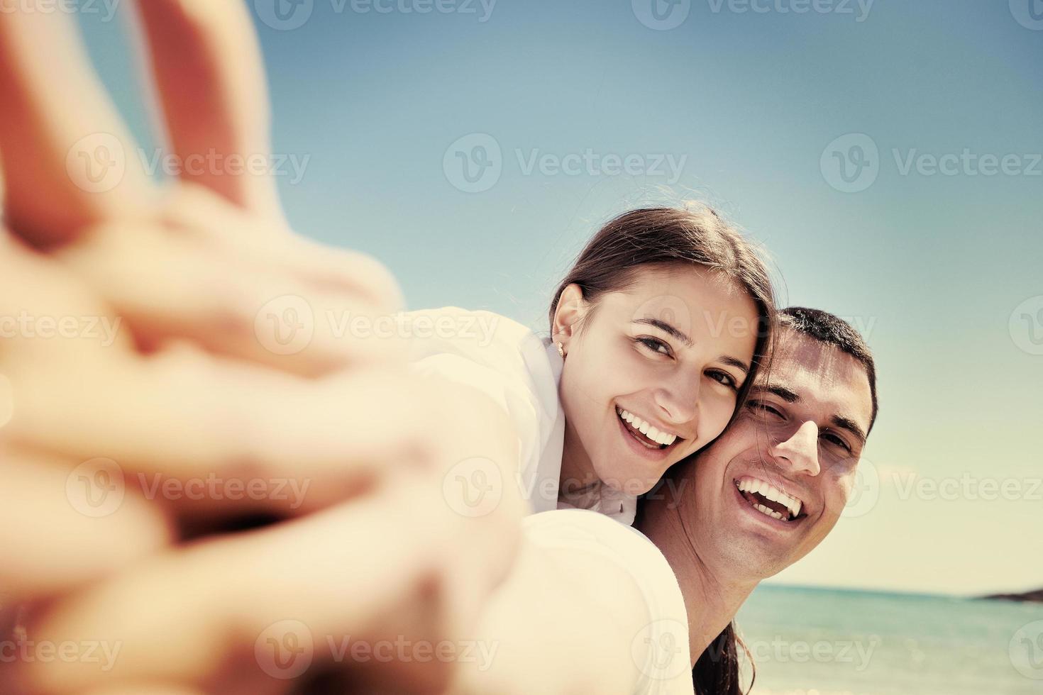 happy young couple have fun on beach photo