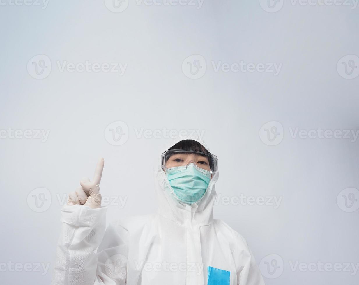 Doctor in PPE suit gesture make hand sign. Represent victory win over virus. photo