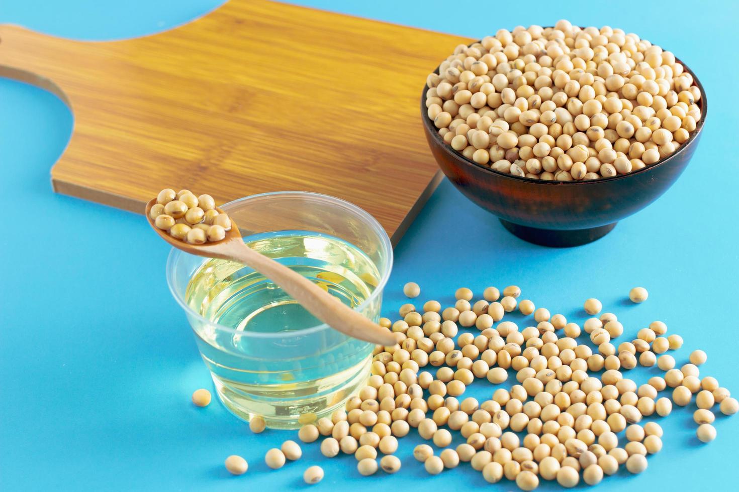 soybean and oil in a bowl on blue background, selective focus.copy space.front view. photo